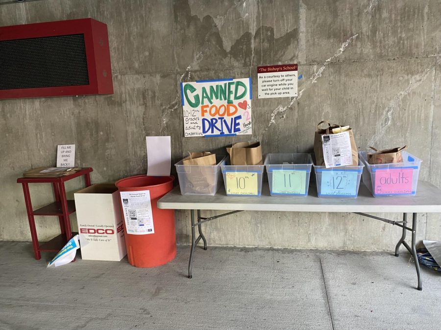 Tables with bins, for the Hearts to Hands food drive from November 4, 2021 to December 13, 2021, near the front of the drop off area filled with bags of canned food highlight the initiative the Bishop’s community has when getting involved to help out others in need. 