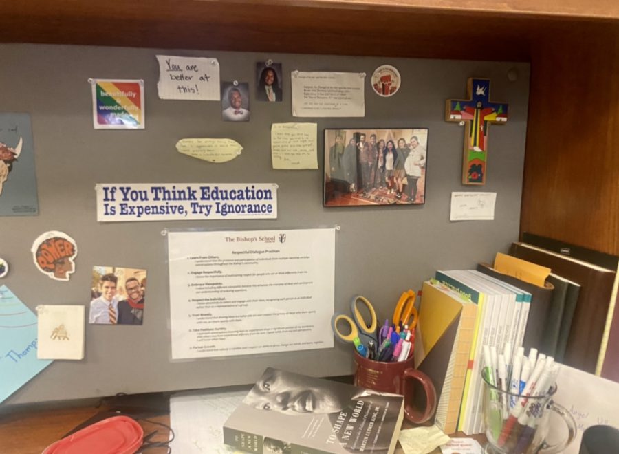 Behind Mr. Thompsons desk is a series of stickers and photos that promote inclusion and love for one another. 