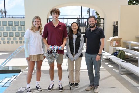 (From left to right) Lexi Black (24), Hewitt Watkins (23), Emily Zhu (23) and Mr. Joshua Bloom take a picture with their ROV that they designed over the course of a couple of months.