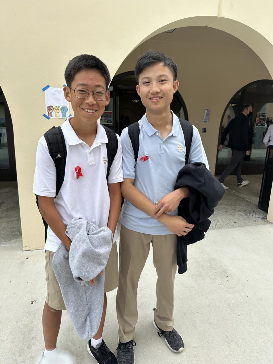 Freshmen Alex Yang (left) and Chris Zheng (right) picked up red ribbons at the table Kindness Crew set up on the terrace for Red Ribbon Week.
