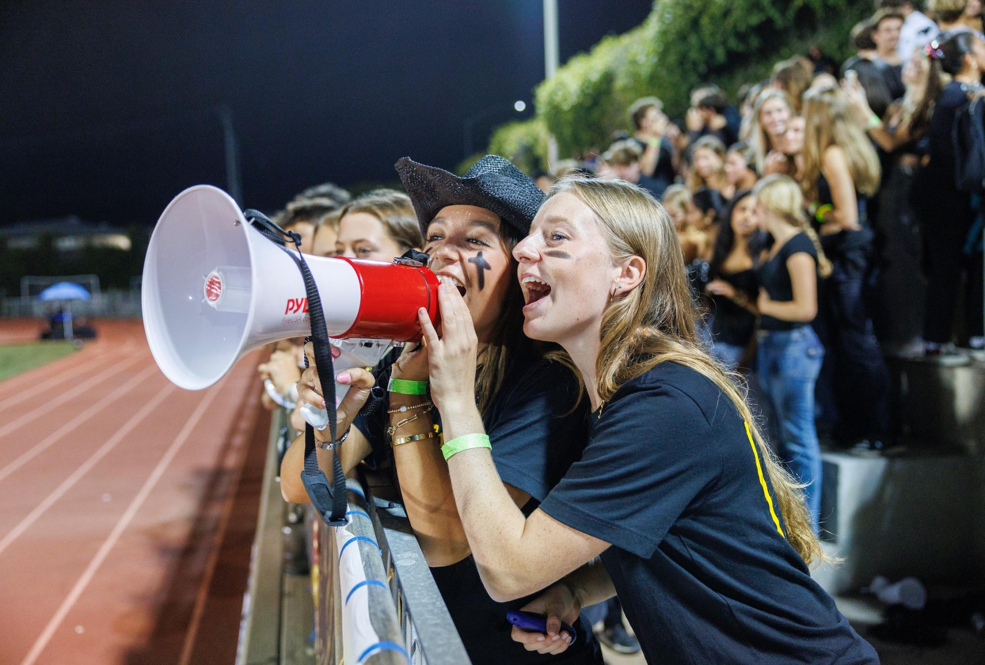 After attracting a full stadium, Dungeon member Laine Jeffery (‘25) and ASB Spirit Representative Kendall Kearney (‘25) take on the megaphone at Bish Bowl, one of the many props they have begun to bring to this year’s games. 