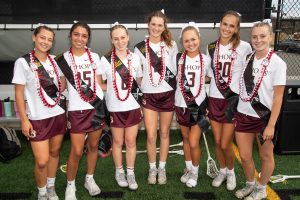 After the game, seniors Natalie Marvin, Kendall Kearney, Mia Gover, Adelaide Kessler, Alex Pfister, Carmen Morrera, and Laine Jefferey stand together after getting their leis from walking through the Knights tunnel after their Senior Night game. 