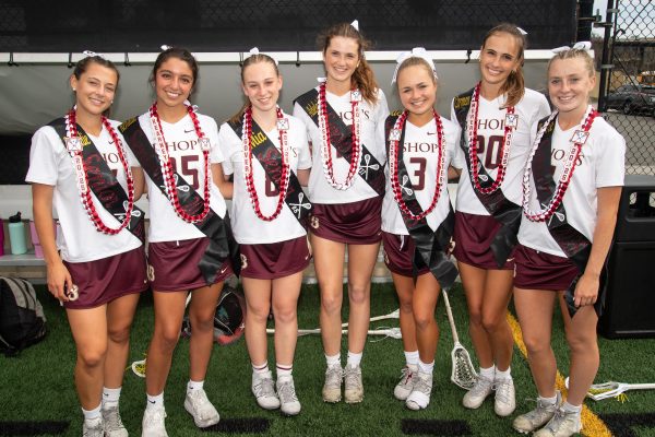 After the game, seniors Natalie Marvin, Kendall Kearney, Mia Gover, Adelaide Kessler, Alex Pfister, Carmen Morrera, and Laine Jefferey stand together after getting their leis from walking through the Knights tunnel after their Senior Night game. 