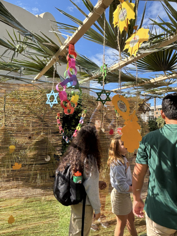 The sukkah also had decorations hanging above the roof of palm fronds and wood beams, which included many stars of David, paper chains, and other jewish ornaments relating to Sukkot. 