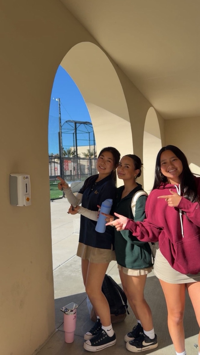 From left to right, Saving Skin members Jasmine Ren (‘27), Serena Abraham (‘27), and Emelyn Huynh (‘27), pose with a newly installed sunscreen dispenser outside the Michael & Marlene Teitelman Science Center. “[It’s] right next to the field, where all the athletes are playing sports out in the sun all pretty much all day,” Serena explained.